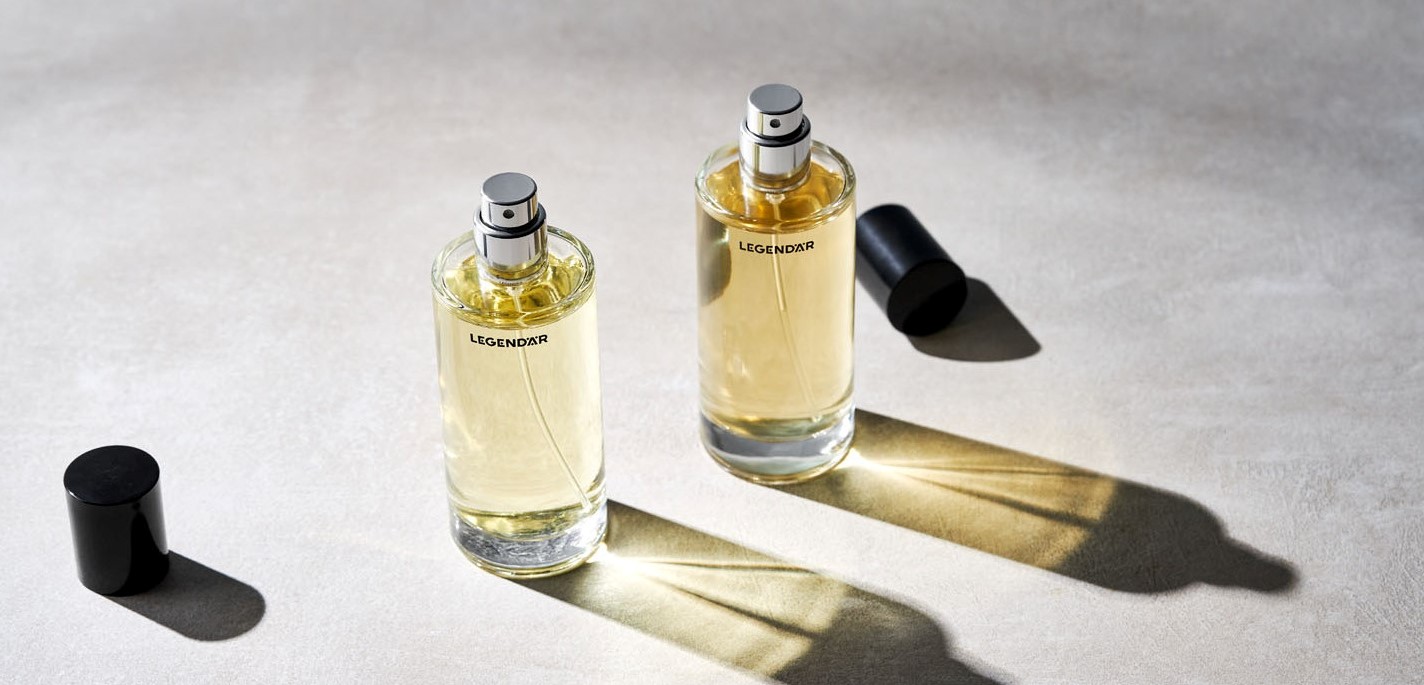 Zwei geöffnete Eau de Parfum Flakons von Legendär mit Licht- und Schattenspiel auf hellem Untergrund